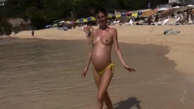 Pregnant and nude babe at the beach